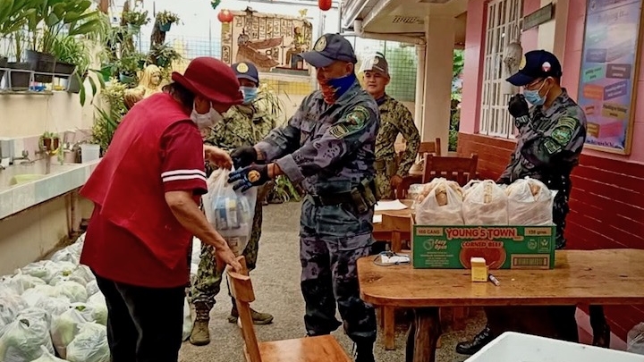    SOCIAL RELIEF. Uniformed personnel assist in the distribution of relief packs in Baguio City. BAGUIO CITY PIO
