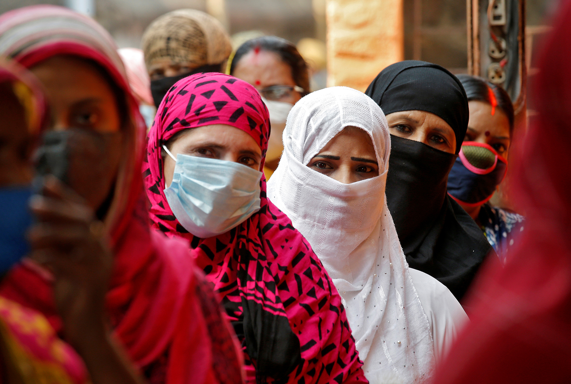 Women wait in line to cast their votes at a polling station in Kolkata